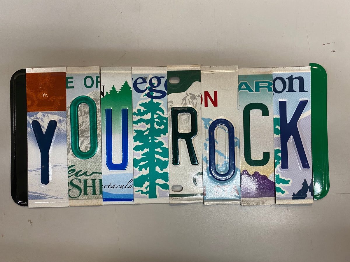 Decorative sign made from license plates with 'YOUR ROCK' text on a white background