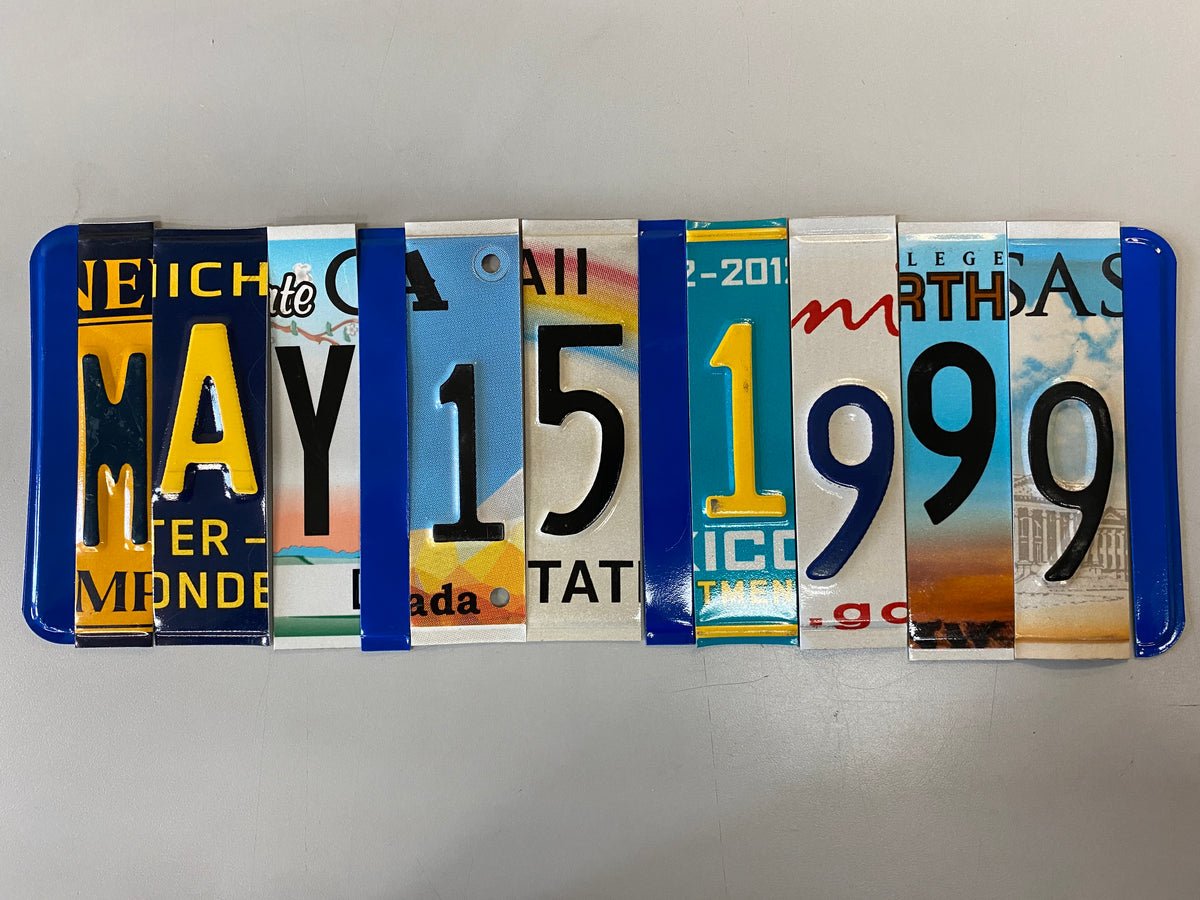 A rectangular row of colorful license plate strips arranged vertically, photographed on a plain light background.