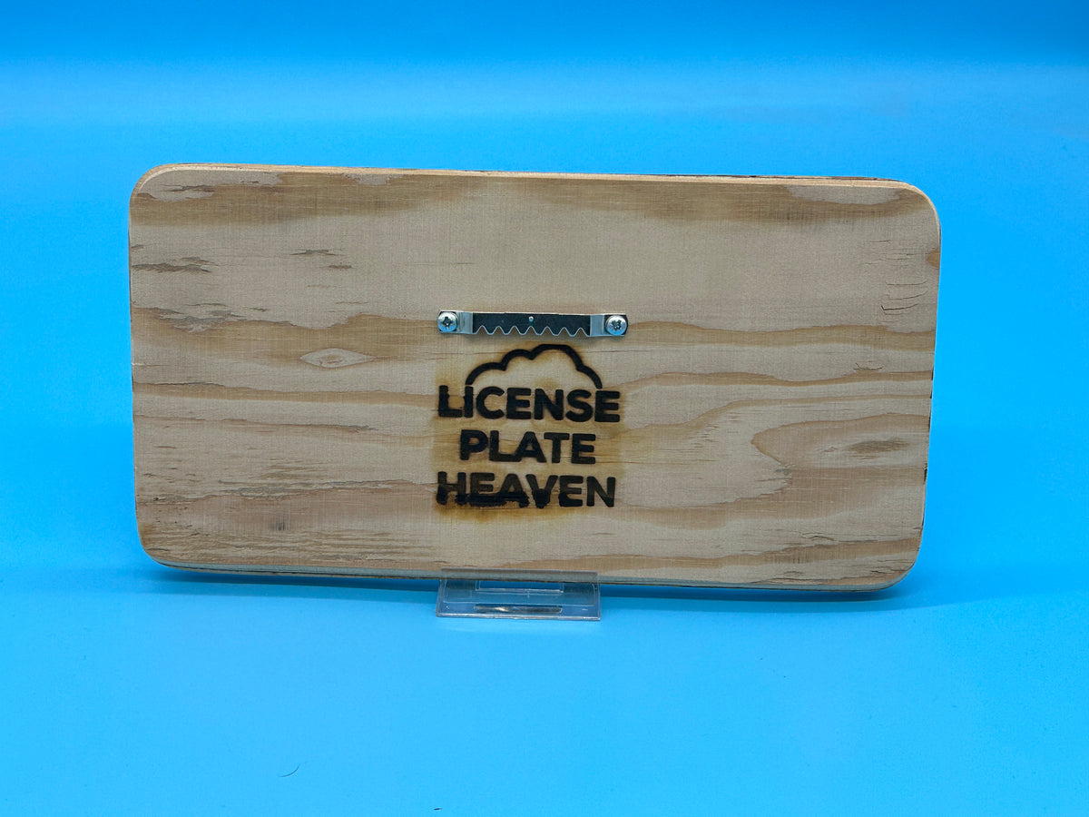 The back of a sign with the company name 'License Plate Heaven' burned into the back with a sawtooth hanger for easy hanging.