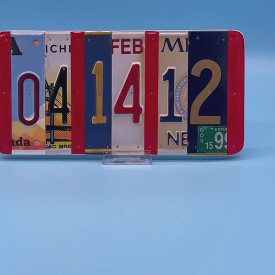 A rectangular decorative wall piece made from  license plates arranged side by side to spell out 04 14 12.