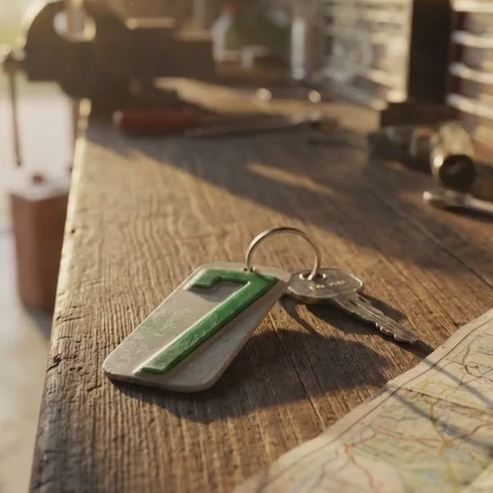 keyring  with 7 from a recycled license plate sitting on a old wood bench